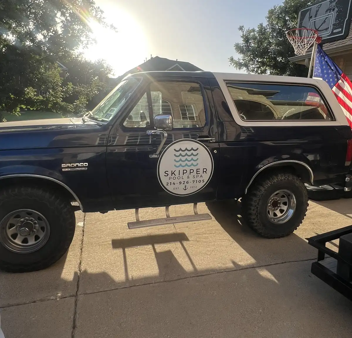 Skipper Bronco with the American flag in a driveway