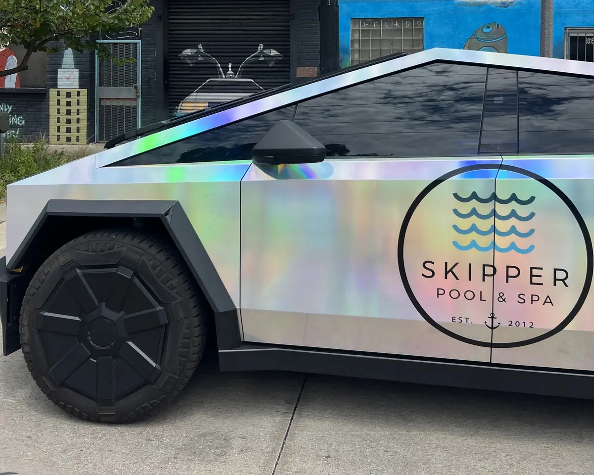 Skipper Cybertruck side view by a painted wall