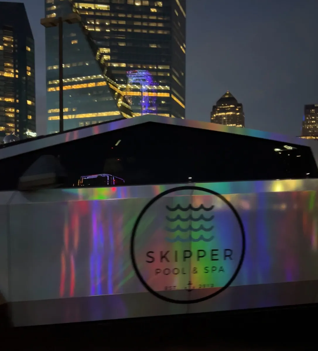 Skipper holographic Cybertruck at night with the Dallas skyline