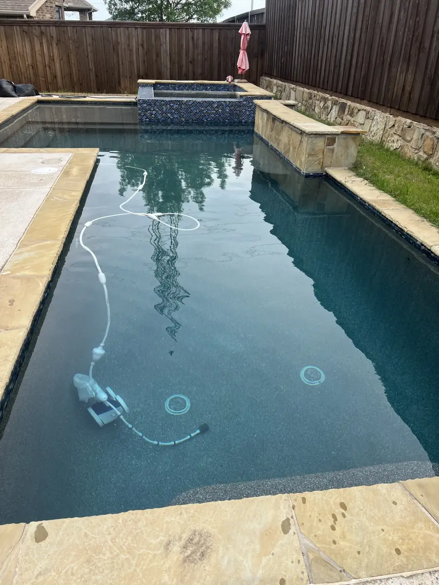 Clear pool at dusk with a cleaner running