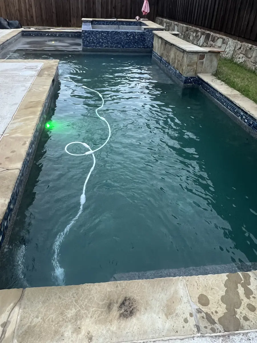 Clear pool at dusk with a cleaner