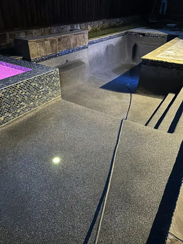 Empty pool at night during a refinish