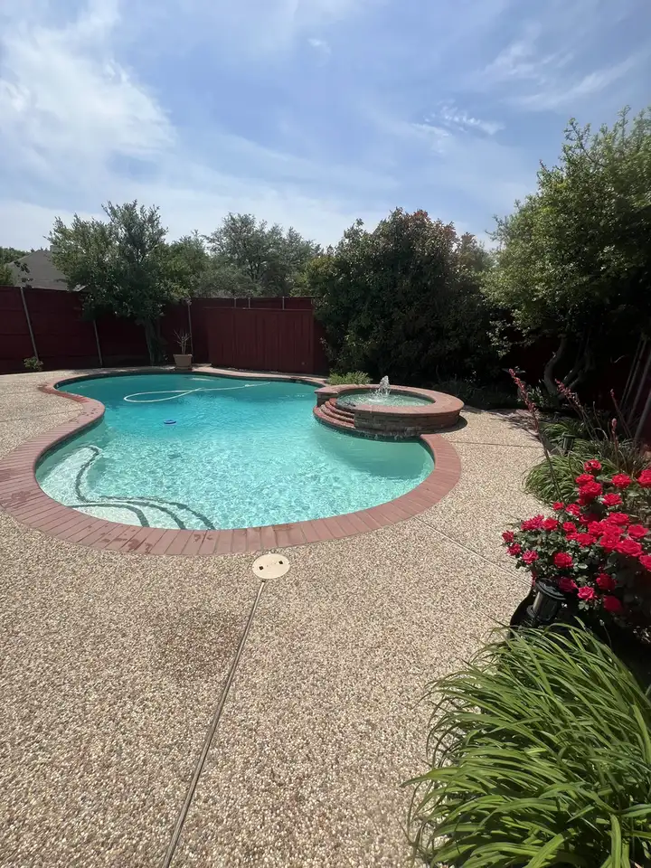 Freeform pool and spa with a brick deck