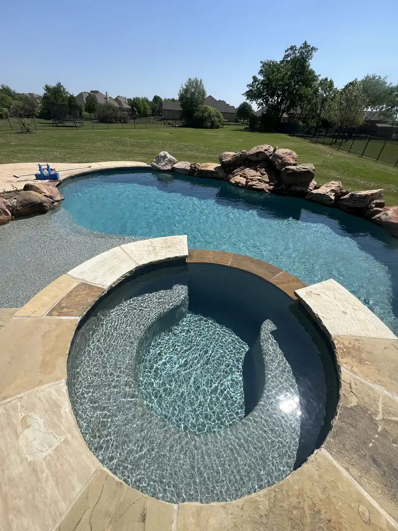 Round spa inside a freeform pool