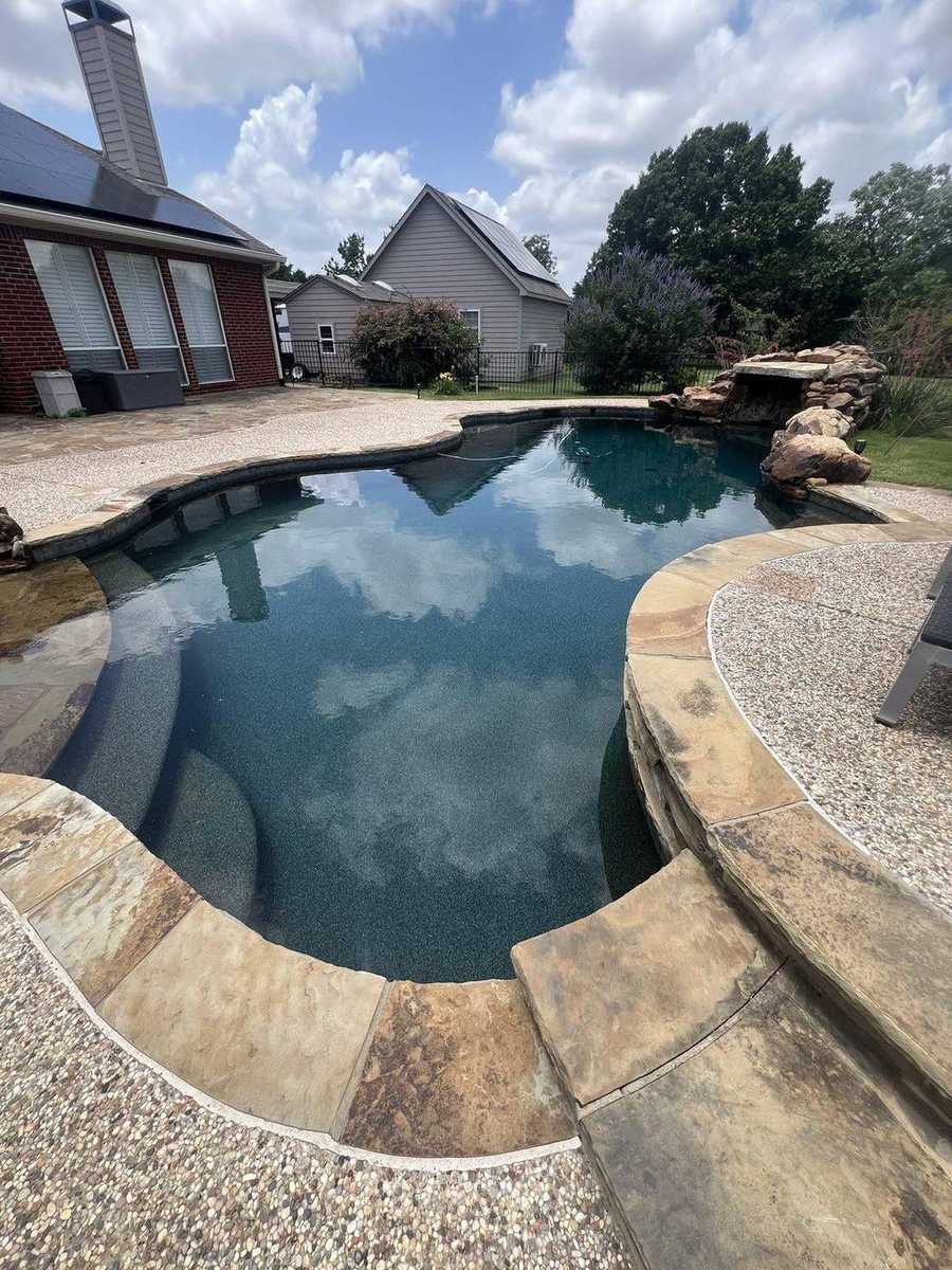 Dark plaster freeform pool with rock waterfall