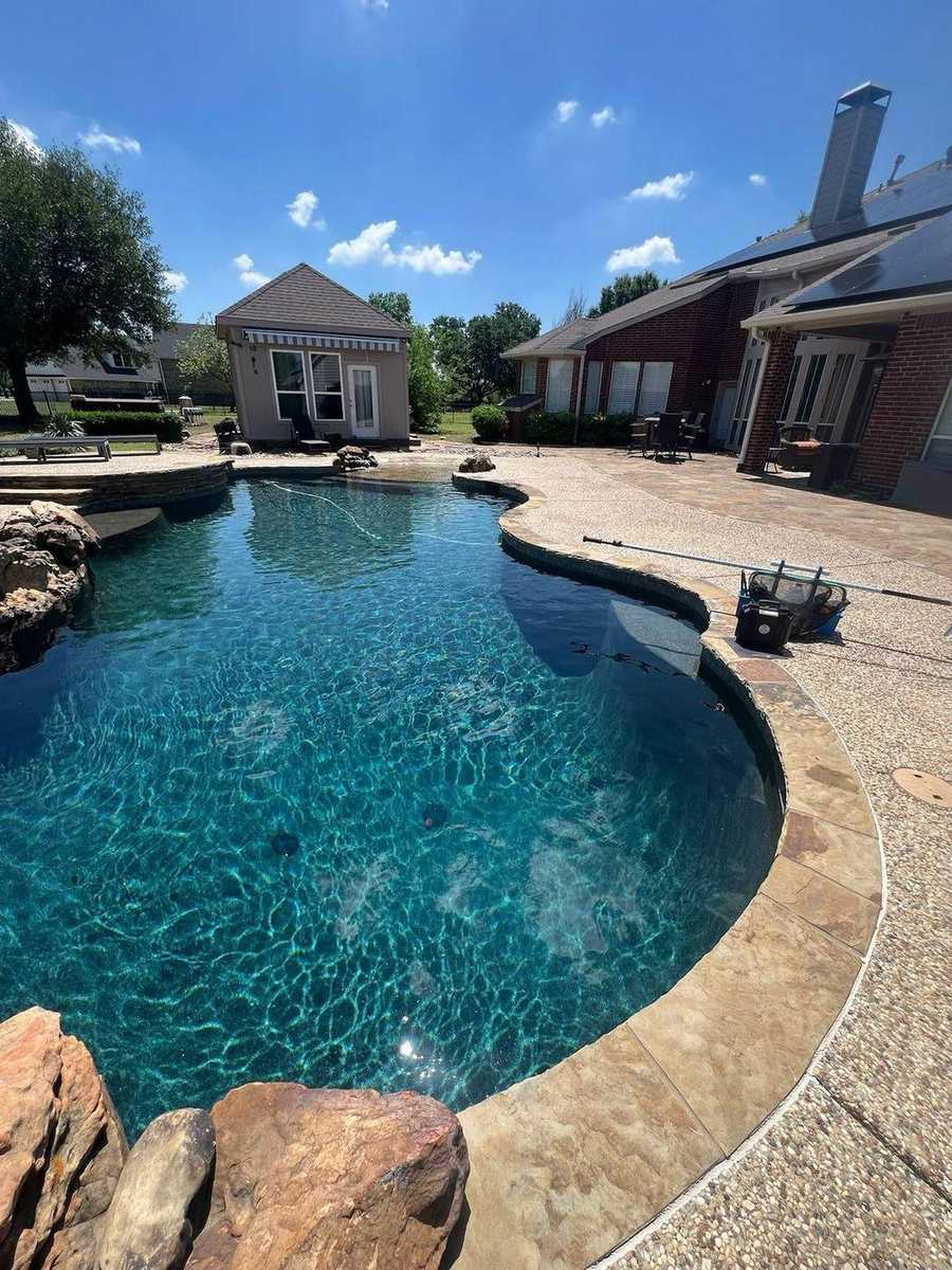 Luxury freeform pool with rock waterfall and pool house