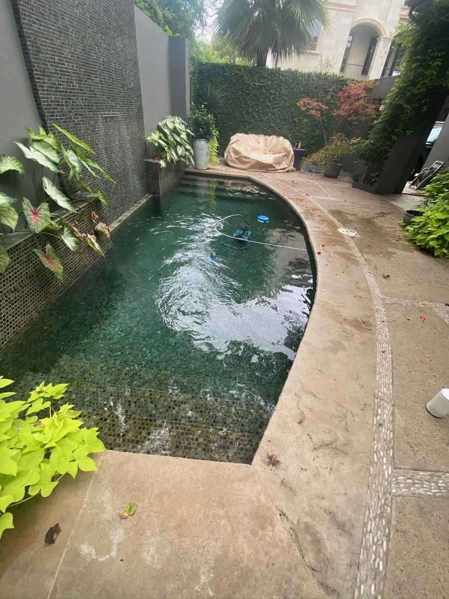 Dark mosaic plunge and lap pool with sheer descent wall