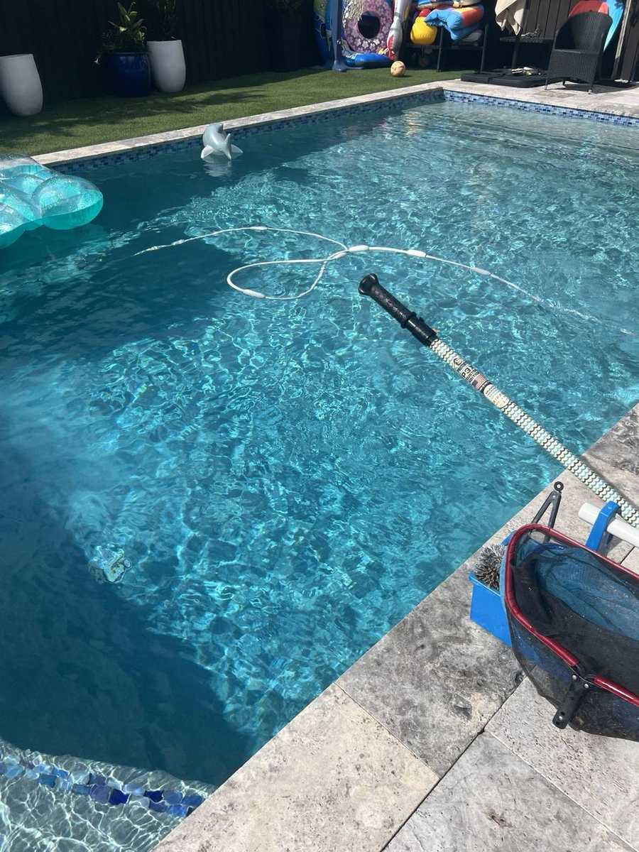 Skimmer and service pole on the pool deck during weekly stop