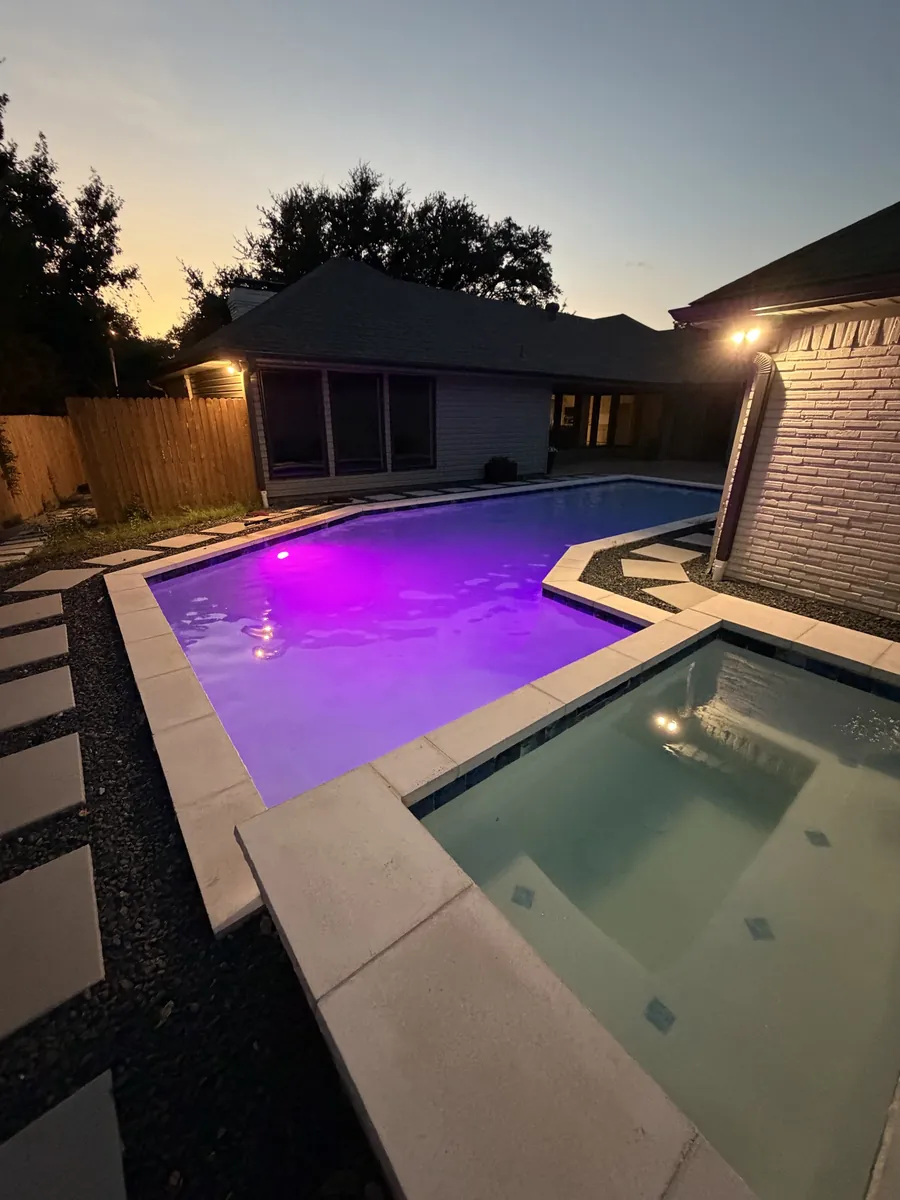 Pool and spa glowing purple at dusk
