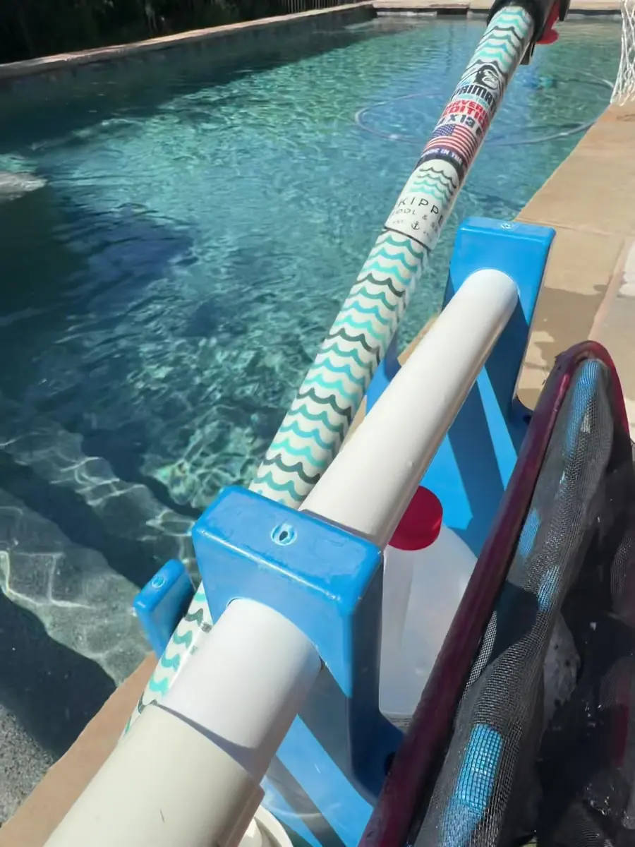 Service pole and brush at the pool edge