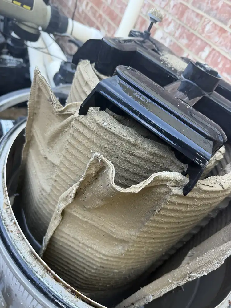 Why filter cleans matter: a torn, clogged filter cartridge pulled from the housing