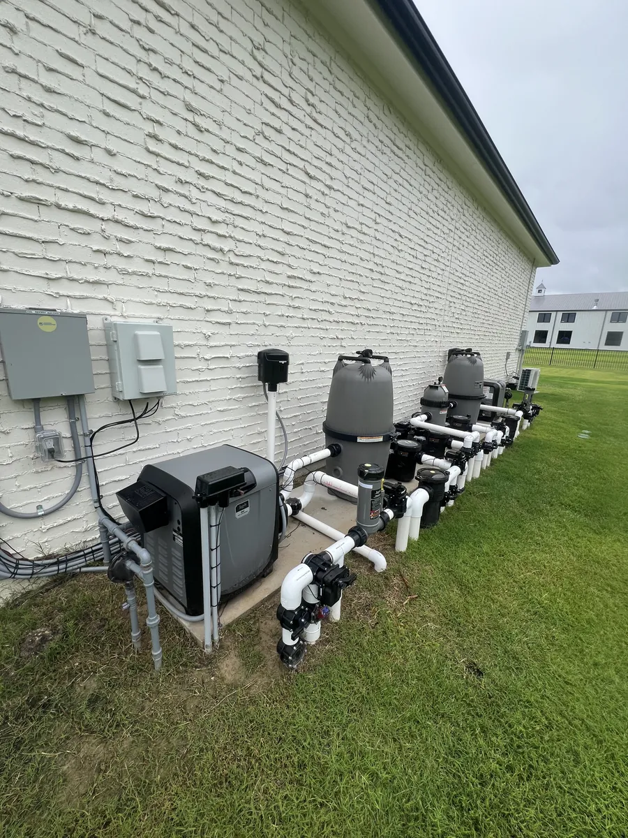 Pool equipment pad with heater, filters, and pumps